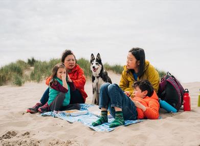 A family having a picnic on the sand at Barmouth beach