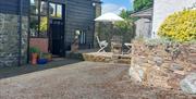 Outside of Granary Cottage, with parking space, Pretty terrace with tables, chairs and sunshade