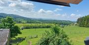 View from upstairs sitting room window showing panoramic views over fields and hills