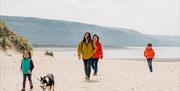 Family walking on Barmouth Beach with their Dog
