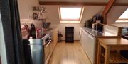 Sociable cooking in the open plan Tollant kitchen. This spacious barn conversion is a great place for getting together with friends.