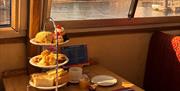 An example of afternoon tea, sandwiches, scones and cakes with hot drinks.