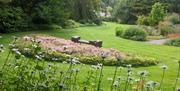 Stone seating overlooking sweeping lawns and flower beds