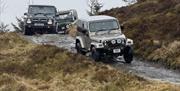Land Rovers in convoy on slight incline