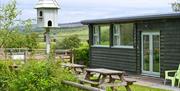 Exterior of Hafren Forest Hideaway with picnic benches, bird feeder, and rural hill views, Mid Wales group accommodation