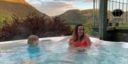 Guests enjoying the Granary hot tub, with views of the hills and farmland to the south.