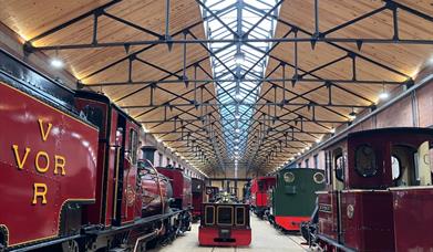 Steam locomotives on display under a glass roof at the Vale of Rheidol Railway in Aberystwyth