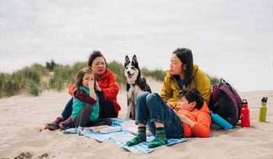 A family having a picnic on the sand at Barmouth beach