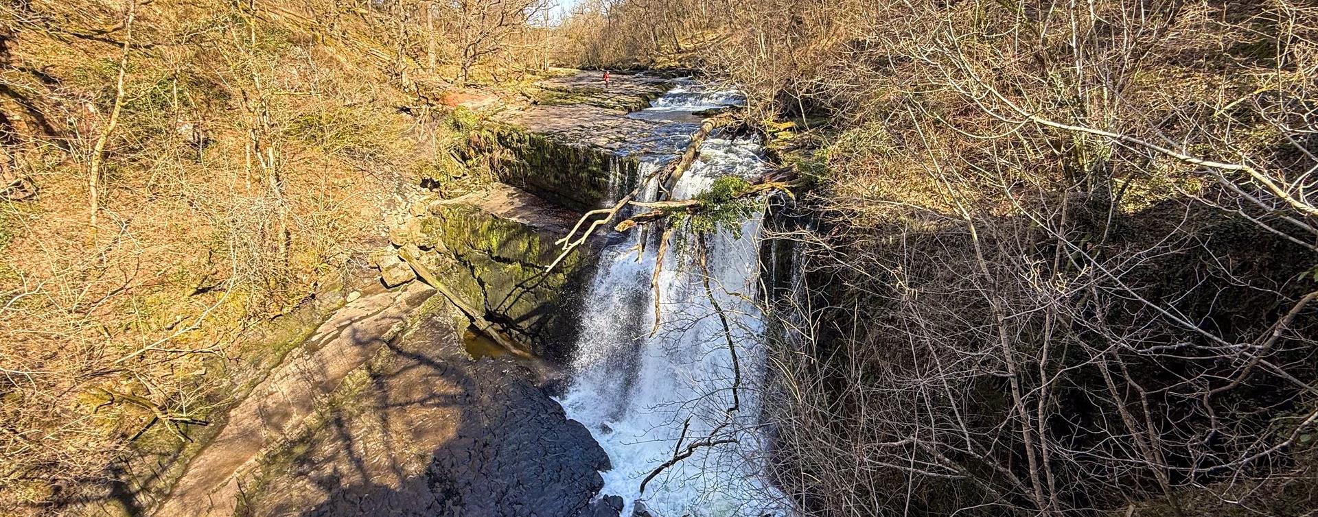 A waterfall in a wooded gorge on the Four Falls Walk in Bannau Brycheiniog