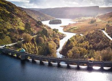 Elan Valley dam with water cascading over Victorian stonework into the river below