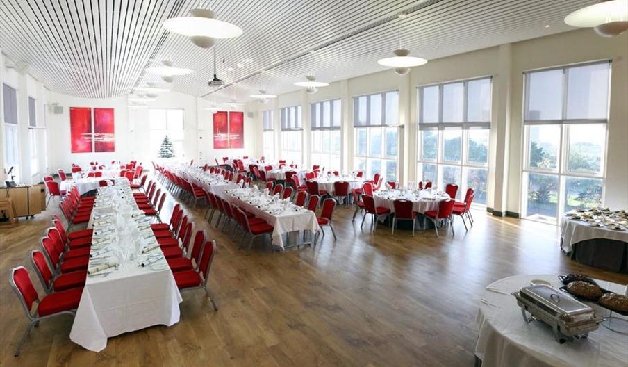 Medrus Mawr Conference Room set up with rows of tables set up for a formal dinner.