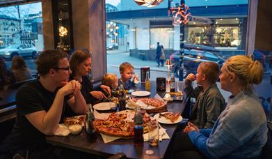 Family eating pizza at PizzaTIA