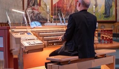 Organist sitter ved orgelet i Hamar domkirke