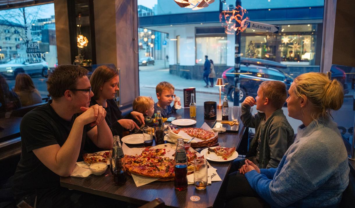 Familie som spiser pizza hos PizzaTIA