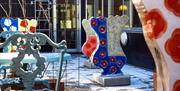 Colorful outdoor sculptures arranged in a courtyard next to a building.