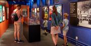 Besøkende studerer interaktive utstillinger i museum. Foto: Kristian Dillerud, Jonas J. Tomter og Ingvild Stubbom