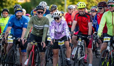 A group of cyclists smile while waiting at the start line in chepstow