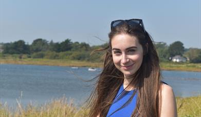 Bethany Handley sat in a a meadow, near water