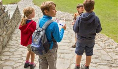 children with bingo notes and pens looking around chepstow castle having fun 
