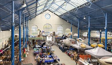 Abergavenny Market Hall historic hall with blue metal roof and art work hanging from roof