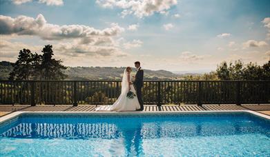 Loveseen photography captured wedding couple by swimming pool at Caer Llan in Monmouthshire