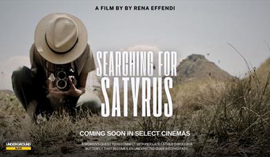 A woman photographing a butterfly - a film flyer for Searching for Satyrus
