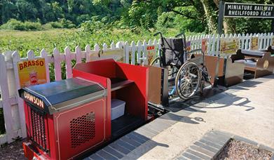 Miniature Railway at Old Station Tintern small red and black train showing a wheelchair carriage - sunny day 