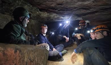 Group of people inside cave with headlamps