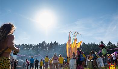 Scene shows a samba band dancing under a beautiful blue sky (without a cloud in it!)