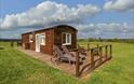 Harvest Home Shepherd Lodges made of wood looks like shepherds hut in field blue skys in monmouthshire near cardiff