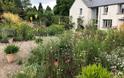 Highfields Farm Garden with rich planting and beautiful design with house in view