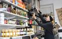 lady fills brown bag with nuts from refillery in little green refills shop