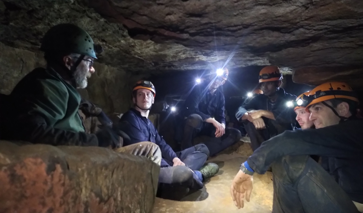 Group of people inside cave with headlamps