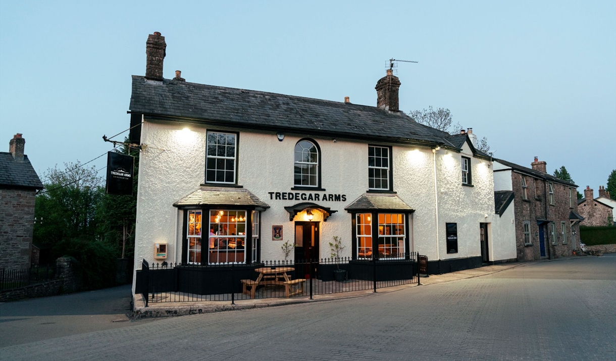 THE TREDEGAR ARMS exterior of building - black and white on the side of the road looks welcoming with warm lights showing through window