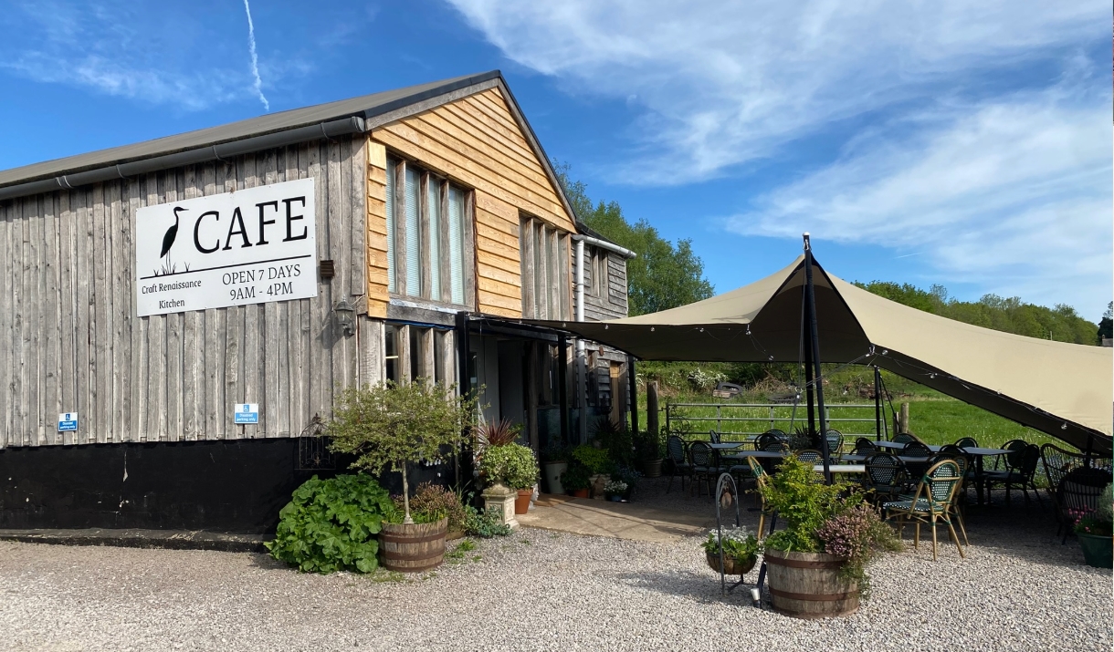 Craft Renaissance Kitchen & Cafe wooden building very stylish with planters and sun canopy, blue sky and green fields in background in rural monmouths