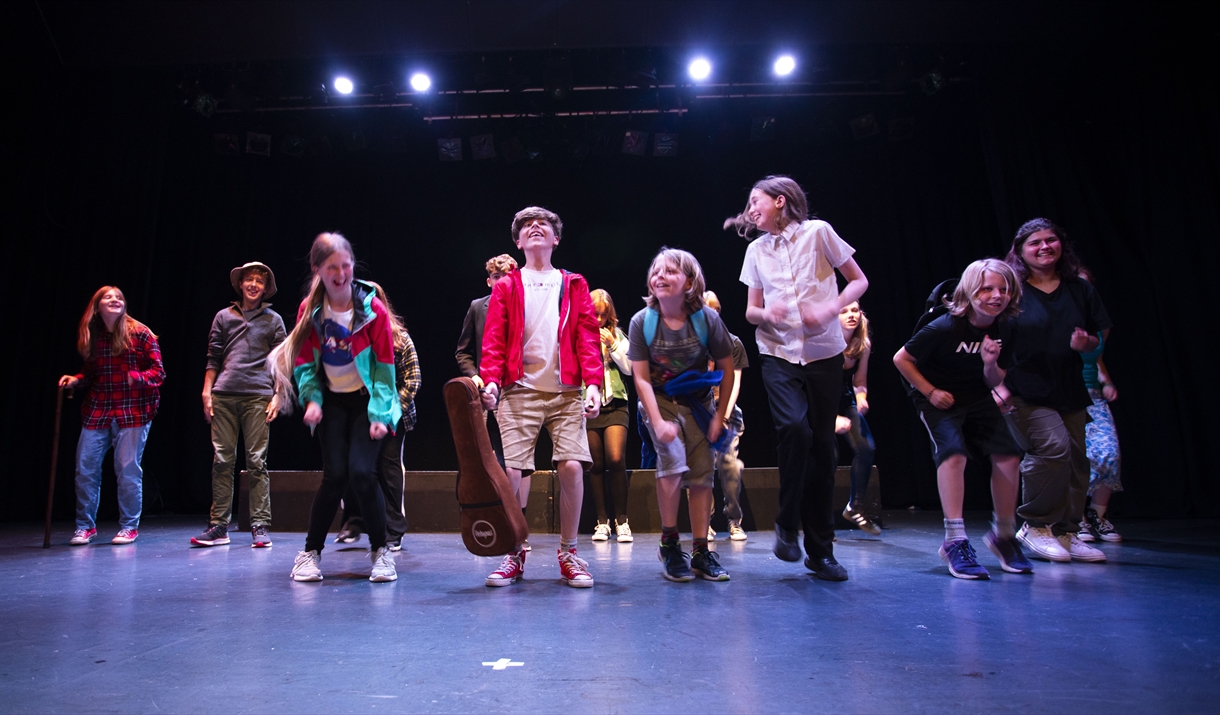 Young people jumping on a theatre stage