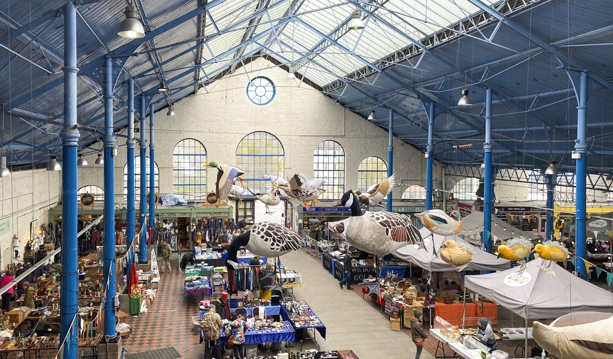 Abergavenny Market Hall historic hall with blue metal roof and art work hanging from roof