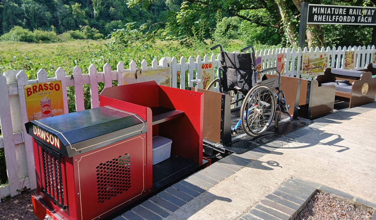 Miniature Railway at Old Station Tintern small red and black train showing a wheelchair carriage - sunny day