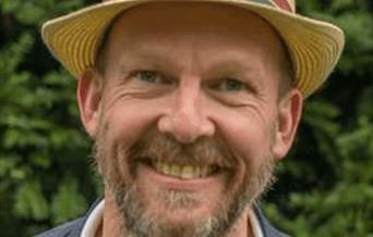 Photo of a smiling man in a straw hat