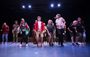 Young people jumping on a theatre stage