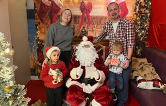 Santa at Llandegfedd Lake in Grotto with a family