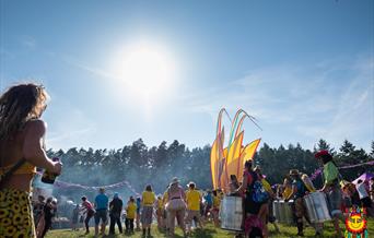 Scene shows a samba band dancing under a beautiful blue sky (without a cloud in it!)