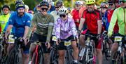 A group of cyclists smile while waiting at the start line in chepstow