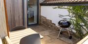 The enclosed terrace of the Blorenge, with a barbecue and a table with two chairs