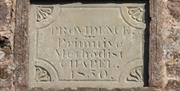 Close up image of name stone inset into chapel wall. The words inscribed read PROVIDENCE Primitive Methodist CHAPEL 1850.