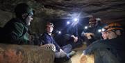 Group of people inside cave with headlamps