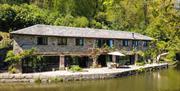 Picture of 2 floor long cottage along canal, outdoor seating and trees surrounding