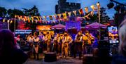 night time, flags and lights as band plays at caldicot castle