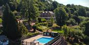Caer Llan set in Monmouthshire landscape with pool and landscaped gardens