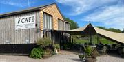 Craft Renaissance Kitchen & Cafe wooden building very stylish with planters and sun canopy, blue sky and green fields in background in rural monmouths